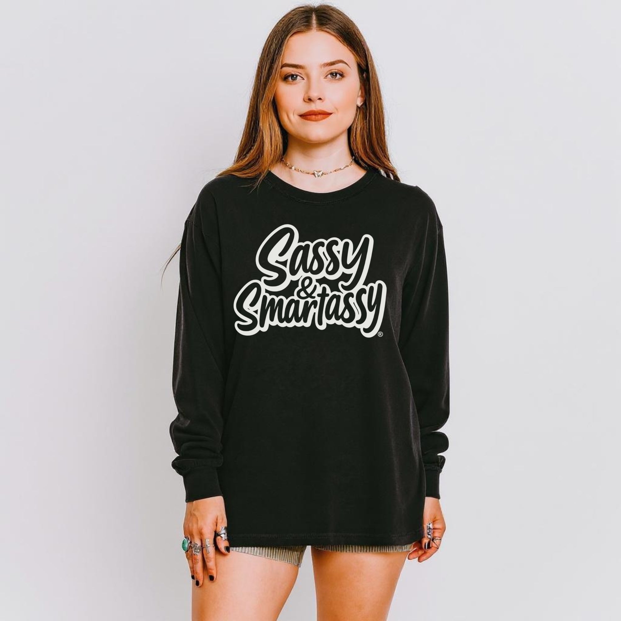 Person wearing a black long sleeve shirt with 'Sassy & Smartassy' text on a plain background