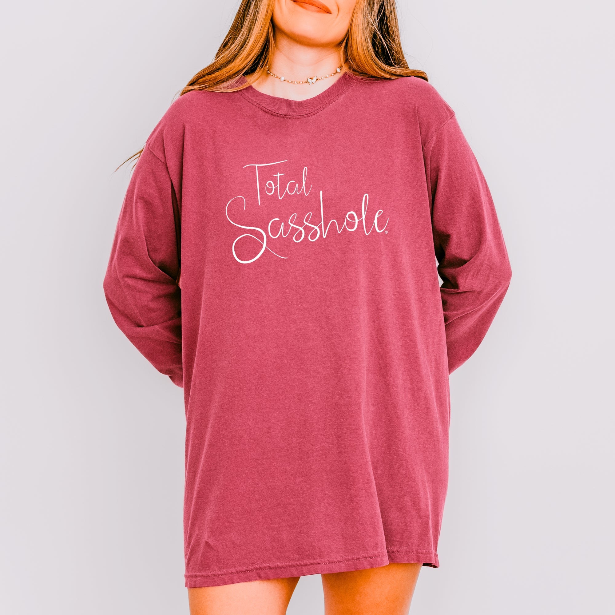 Image of Woman wearing a brick long-sleeve shirt with 'Total Sasshole' text on a plain background