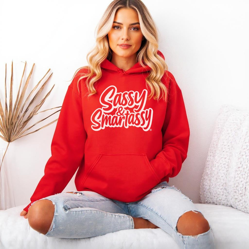 Image of Person wearing a red hoodie with 'Sassy & Smartassy' text, sitting on a white couch.