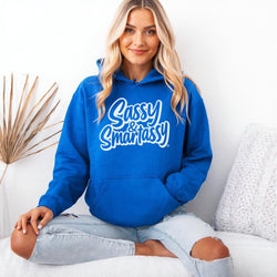 Image of Woman wearing a royal blue hoodie with 'Sassy & Smartassy' text, sitting on a white couch.