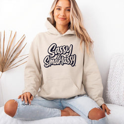 Image of Person wearing a sand hoodie with 'Sassy & Smartassy' text, sitting on a white couch.
