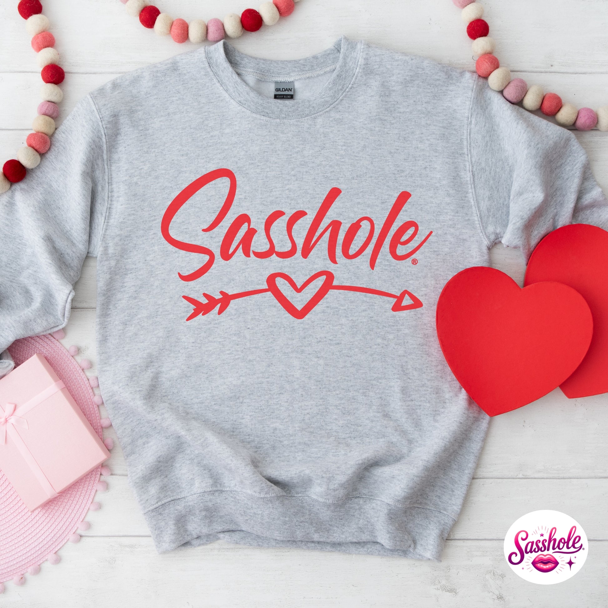 Gray sweatshirt with 'Sasshole' text and red hearts on a white background