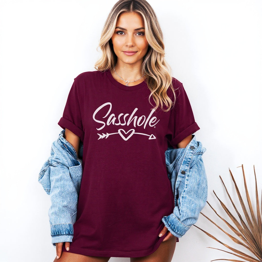 Image of Woman wearing a maroon t-shirt with 'Sasshole' text, standing against a white background.